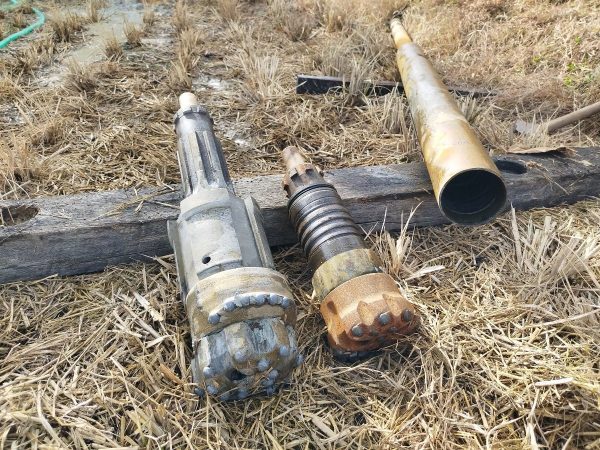 左は崩壊防止パイプ打込み用ハンマービット、中は通常掘削用ハンマービット、右のパイプ状の中にハンマーやバルブなどが入っているエアハンマー本体