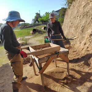 山を削って土をフルイに通す